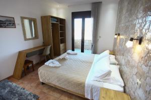 a bedroom with a bed and a desk in it at Panorama Studios in Kefalos