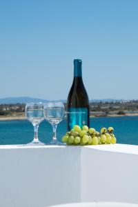 Una botella de vino y dos copas en una mesa. en Georgia Mare, en Naxos Chora