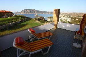 a balcony with a couch and a chair and a view at Panorama Studios in Kefalos
