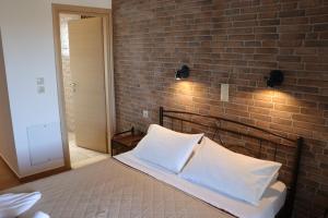 a bed in a room with a brick wall at Panorama Studios in Kefalos