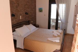 a bedroom with a bed and a brick wall at Panorama Studios in Kefalos