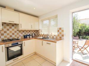 a kitchen with a sink and a stove at Firkin Cottage in Weymouth