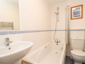a white bathroom with a sink and a toilet at Firkin Cottage in Weymouth +14 photos