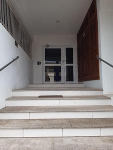 een witte kamer met een trap en een raam bij Apto JK Universitário - Express in Santa Cruz do Sul