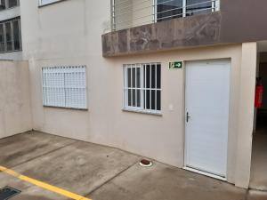 un edificio blanco con una puerta de garaje blanca en Apto JK Universitário - Express, en Santa Cruz do Sul