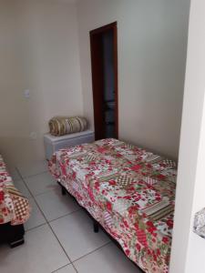 Un dormitorio con una cama con una manta de flores. en Apto JK Universitário - Express, en Santa Cruz do Sul