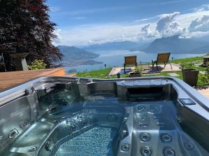 a hot tub with a view of the water at Private Luxury Spa & Silence Retreat with Spectacular View over the Lake Maggiore in Stresa