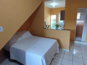 a bedroom with a white bed in a room at Loftzinho Angra dos Reis in Angra dos Reis