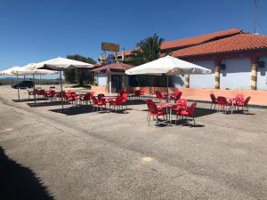 un groupe de tables et de chaises avec parasols dans l'établissement Hostal Restaurante LA CEPA, à Cenicero