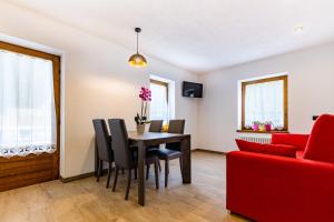 a living room with a dining room table and a red couch at Casa Silver in Valdidentro