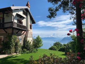 um edifício com uma varanda num relvado verde em Private Luxury Spa & Silence Retreat with Spectacular View over the Lake Maggiore em Stresa