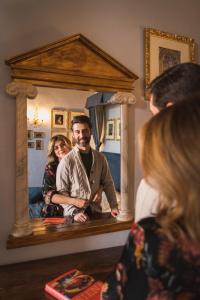 Ein Mann, der mit einer Frau vor einem Spiegel steht. in der Unterkunft Palazzo Ravizza in Siena