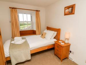 a small bedroom with a bed and a window at Spout Cottage in Sedbergh