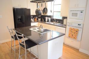 a kitchen with a sink and a black refrigerator at Modern B & B in Houston