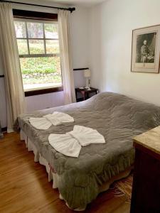 a bedroom with a bed with towels on it at Fachoalto Budget in Petrópolis