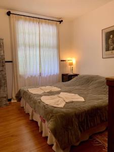 um quarto com uma cama com lençóis brancos e uma janela em Fachoalto Budget em Petrópolis