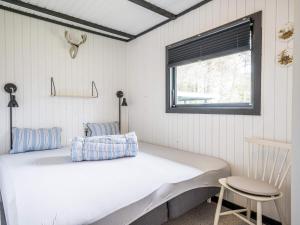 een bed in een kamer met een raam en een stoel bij 5 person holiday home in Vejers Strand in Vejers Strand