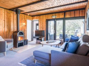 een woonkamer met een bank en een open haard bij 5 person holiday home in Vejers Strand in Vejers Strand