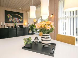 a kitchen with a vase of flowers on a counter at 8 person holiday home in Bl vand in Blåvand