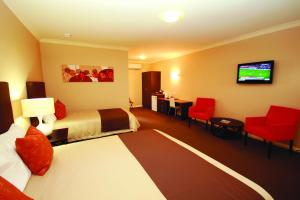 Sundowner Motel Hotel في وايالا: غرفة فندقية بسريرين وتلفزيون بشاشة مسطحة