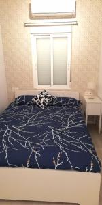 1 dormitorio con 1 cama con edredón azul en Precioso Apartamento frente del Mercado Central en Valencia