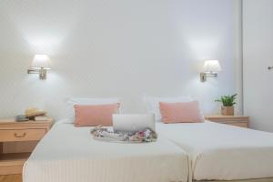 a white bed with a laptop on top of it at Delice Hotel - Family Apartments in Athens