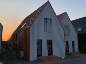 a large barn with a white and red roof at Aurora apartments in Palanga