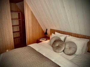 a bed with two pillows on top of it at Aurora apartments in Palanga