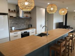 a kitchen with a counter with a sink and some lights at Holiday Comfort in Twizel