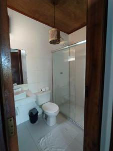 a bathroom with a toilet and a glass shower at Pousada dos Cardeais in Barra Grande