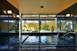 uma grande sala de vidro com uma piscina de água em KKR Kyoto Kuniso em Quioto