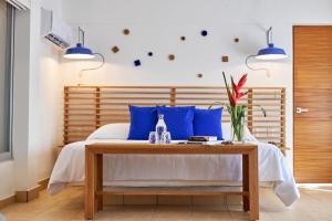 a bedroom with a bed with blue pillows and a table at Hotel Casa de sal in Acapulco