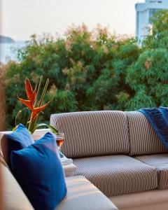 un sofá con almohadas azules sentado en un porche en Hotel Casa de sal, en Acapulco