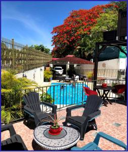 une terrasse avec des chaises, une table et une piscine dans l'établissement Villa Labrousse (Atypical), au Gosier