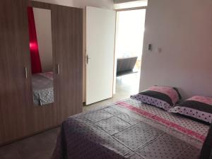 a bedroom with a bed with two pillows and a mirror at YOLANDA HIBISCUS in Le Moule