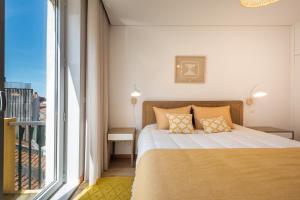 una camera da letto con un letto e una grande finestra di Casa das Musas 2 a Porto