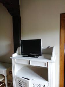 einen TV auf einem weißen Tisch in der Unterkunft Room in BB - Angelas Garden Inn in Santander