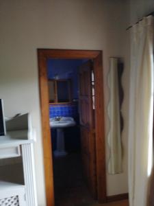 eine Tür, die zu einem Bad mit einem Waschbecken führt in der Unterkunft Room in BB - Angelas Garden Inn in Santander