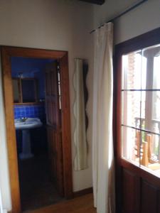 ein Bad mit einem Waschbecken und einer Tür zu einem Zimmer in der Unterkunft Room in BB - Angelas Garden Inn in Santander