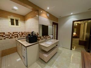 ein Bad mit einem Waschbecken und einem Spiegel in der Unterkunft Quartz Executive in Abha