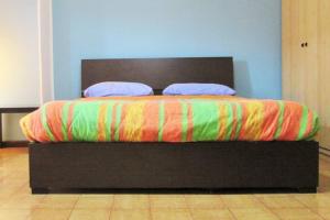 un letto con una coperta colorata e due cuscini sopra di Sky Sunset a Milano
