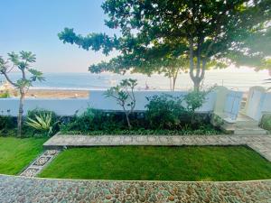 a garden with a view of the beach at Solaluna Beach Homestay in Amed