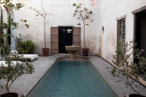 a pool in the middle of a courtyard with a fountain at Casa Olivia in Mérida