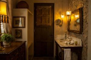 a bathroom with a sink and a mirror and a door at Casa Olivia in Mérida