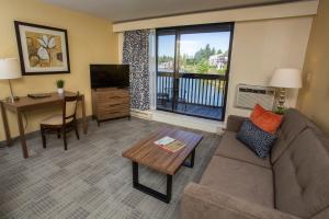 sala de estar con sofá, mesa y TV en Lakeshore Inn, en Lake Oswego