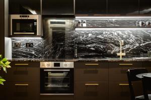 a kitchen with a marble counter top with a stove at The Acacia, Luxury with Private Balcony + Parking in Leicester