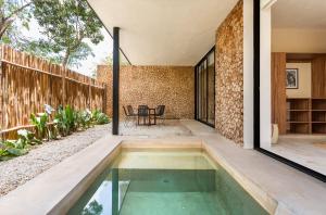 an indoor pool in the backyard of a house at Tuluna Tulum Hotel in Tulum