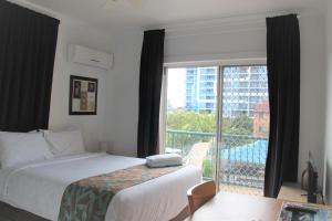 a hotel room with a bed and a large window at Broadwater Keys Holiday Apartments in Gold Coast
