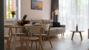 een woonkamer met een tafel en een bank bij Apartamenty BALTIVIA Olimpijska 2 in Mielno