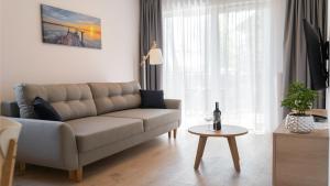 een woonkamer met een bank en een tafel bij Apartamenty BALTIVIA Olimpijska 2 in Mielno